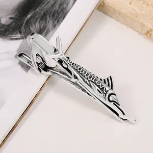 Detail of silver fish-shaped tie clip with embossed scales and metallic textures