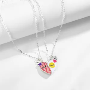 Close-up of magnetic heart BFF necklaces featuring cartoon bacon and egg enamel pendants