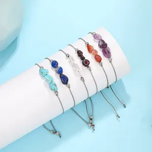 Detail of multi-colored irregular natural stone beads on gray braided cord bracelets