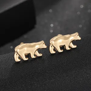 Detailed macro view of high-polished golden polar bear cufflinks on dark background