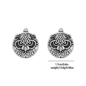 Detailed macro view of vintage owl cufflinks with fine feather textures and antique silver finish