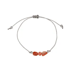 Detail of handmade braided cord bracelet featuring irregular reddish natural stone beads