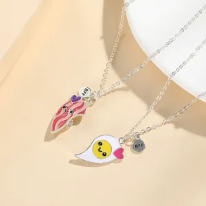 Detailed view of BFF necklaces featuring cartoon egg and bacon pendants with enamel hearts