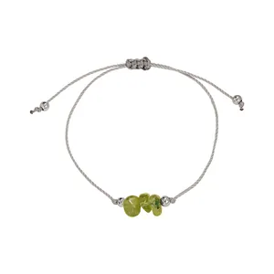 Detail of handmade braided rope bracelet with irregular green stones and silver beads