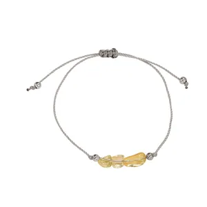 Close-up of adjustable grey cord bracelet with irregular natural yellow raw stones