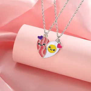 Detail of magnetic BFF necklace featuring cartoon bacon and fried egg heart pendants
