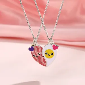 Detail of magnetic BFF necklaces featuring cartoon bacon and egg heart pendant on pink silk
