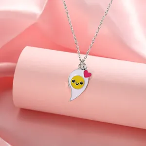 Detail of egg BFF necklace with cartoon fried egg pendant on pink silk display