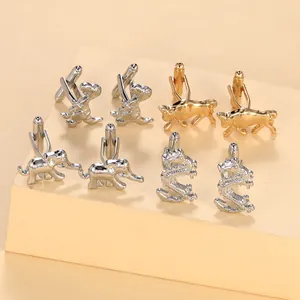 Detailed view of animal-shaped cufflinks featuring lion and dragon in silver and gold