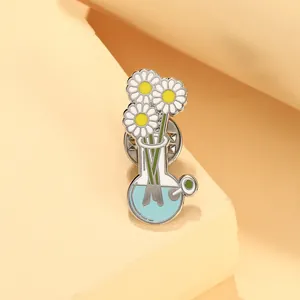 Detail showing white daisy flowers inside a blue laboratory flask enamel pin with metal back