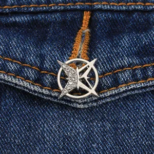 Nahaufnahme einer silbernen Hexagramm-Brosche mit Strass auf dunkelblauem Denim
