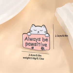 Macro-opname van de cartoon kat emaille speld met Always be pawsitive tekst en metaal