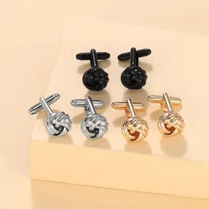 Close-up of woven knot cufflinks in polished silver, gold, and black for men