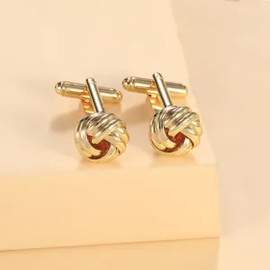 Macro shot of gold woven knot cufflinks with bullet back closure on a neutral display