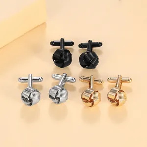 Macro detail of men's silk knot cufflinks in black, silver and gold finishes