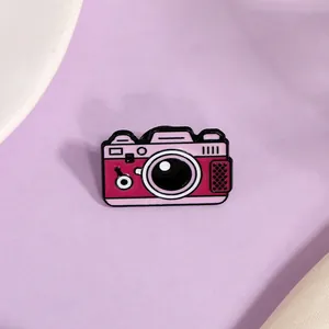Pink and magenta vintage camera enamel pin with black metal outline for denim bags