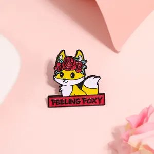 Dettaglio ravvicinato della spilla in smalto a volpe con testo Feeling Foxy e rose