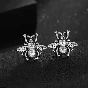 Dettaglio macro dei gemelli a forma di insetto argento con finitura vintage e ali traforate
