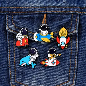 Détail de pins d'astronaute en émail affichés sur une poche de veste en jean bleue