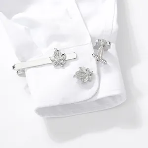 Silver maple leaf cufflinks and tie clip set for men displayed on a white dress shirt