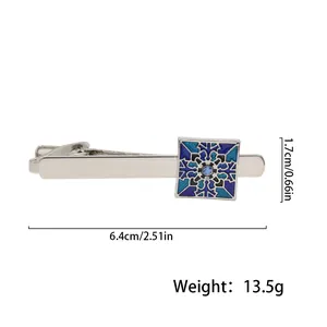 Detail view of a silver tie clip with blue geometric pattern and rhinestone 6.4cm