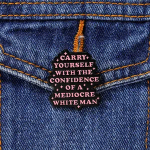 Detail of pink artistic quote enamel pin on dark denim jacket with cloud shape and stars