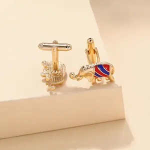 Detailed close-up of gold elephant cufflinks featuring red and blue enamel stripes