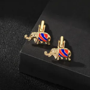 Detail of golden elephant cufflinks featuring vibrant red and blue enamel stripes