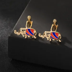 Detailed macro view of golden elephant cufflinks with red and blue enamel stripe patterns