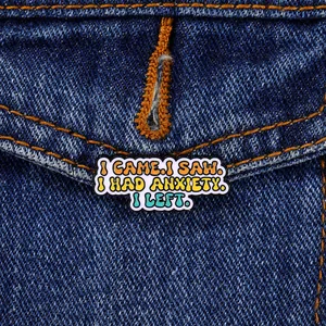 Detail of creative enamel pin on denim jacket with funny social anxiety phrase engraving