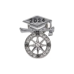 2024 graduation cap brooch with compass ring and crystal accents on a white background