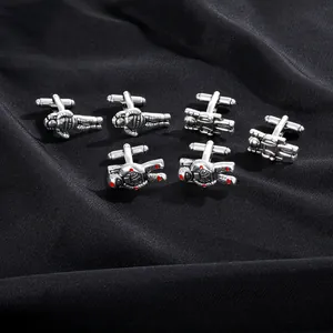 Detailed macro view of silver astronaut cufflinks with vintage finish on black silk fabric