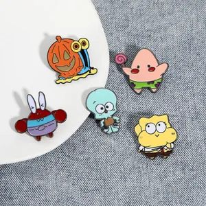 Macro shot of cute cartoon enamel pins featuring SpongeBob characters on denim fabric