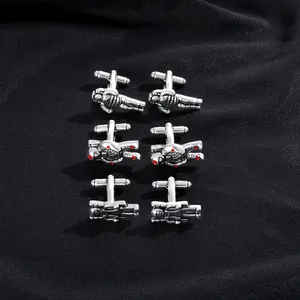 Detailed view of silver astronaut cufflinks set on premium black silk fabric