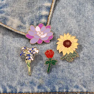 Vue détaillée de quatre broches en émail fleuries sur denim avec tournesol et motifs de rose
