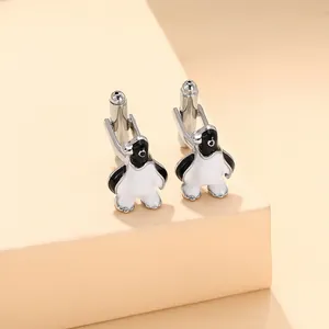 Detail view of silver penguin cufflinks with black and white enamel finish for men