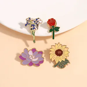 Lot de quatre broches en émail fleuries avec tournesol et rose avec placage doré