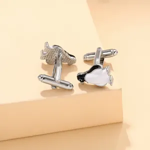 Detailed view of silver penguin cufflinks with black and white enamel on a neutral block