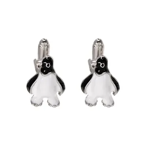 Detailed view of silver penguin cufflinks with black and white enamel and T-bar fastening