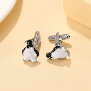 Detailed close-up of penguin cufflinks with silver-tone metal and enamel finish