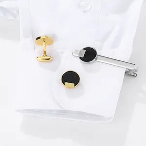 Men's business set with golden round starlight cufflinks and polished silver tie clip
