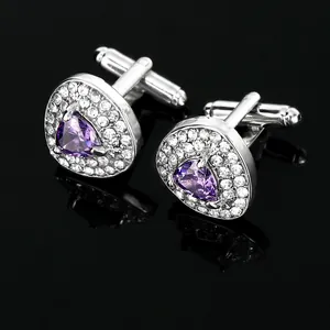 Detail view of silver cufflinks featuring a triangle purple crystal and pavé stones