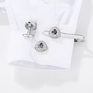 Silver cufflinks and tie clip set with purple crystal and white stones on white shirt