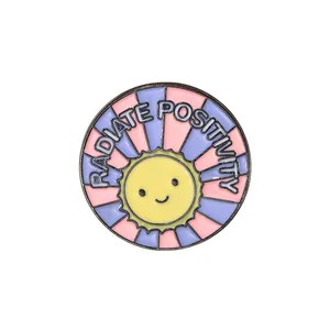 Emaillierte Sonnen-Anstecknadel mit Radiate Positivity Text und bunten Strahlen