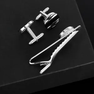 Polished silver cufflinks and tie clip set with black round inserts in a gift box
