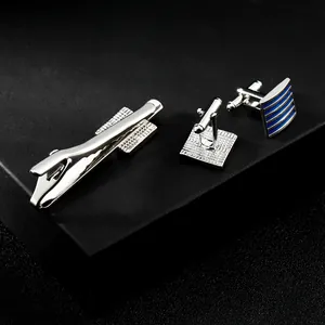 Dettaglio dei gemelli da polso argento e blu con fermacravatta in confezione regalo