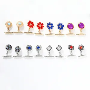 Detailansicht von Vintage-Manschettenknöpfen mit bunten Blumenmustern und Perlen