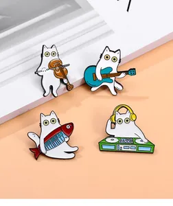Detail von vier weißen Katzen-Emaille-Pins mit Musikinstrumenten auf Büchern
