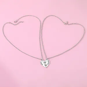 Detail of mother and daughter heart pendant necklaces with butterfly on pink background