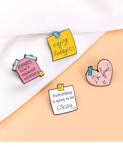 Gros plan de quatre pin's en émail pastel avec des slogans inspirants en langue anglaise